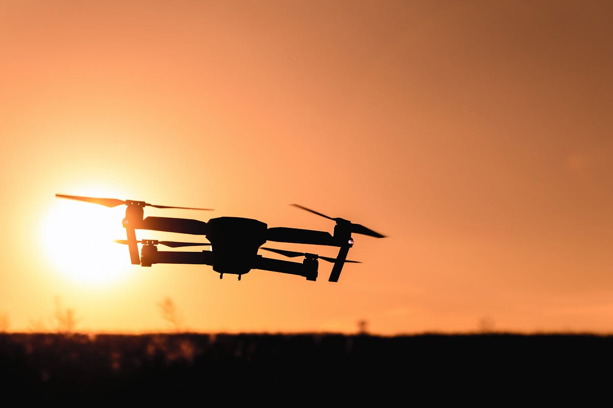 Quadcopter drone hovering against an open sky